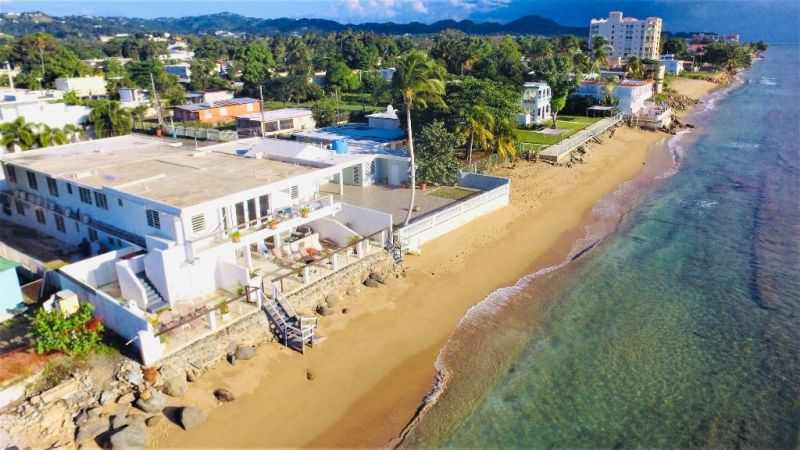 Vista aérea de la casa frente al mar con aguas claras