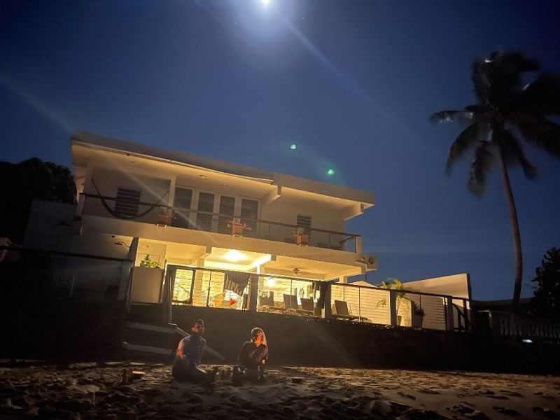 La casa iluminada de noche desde la playa